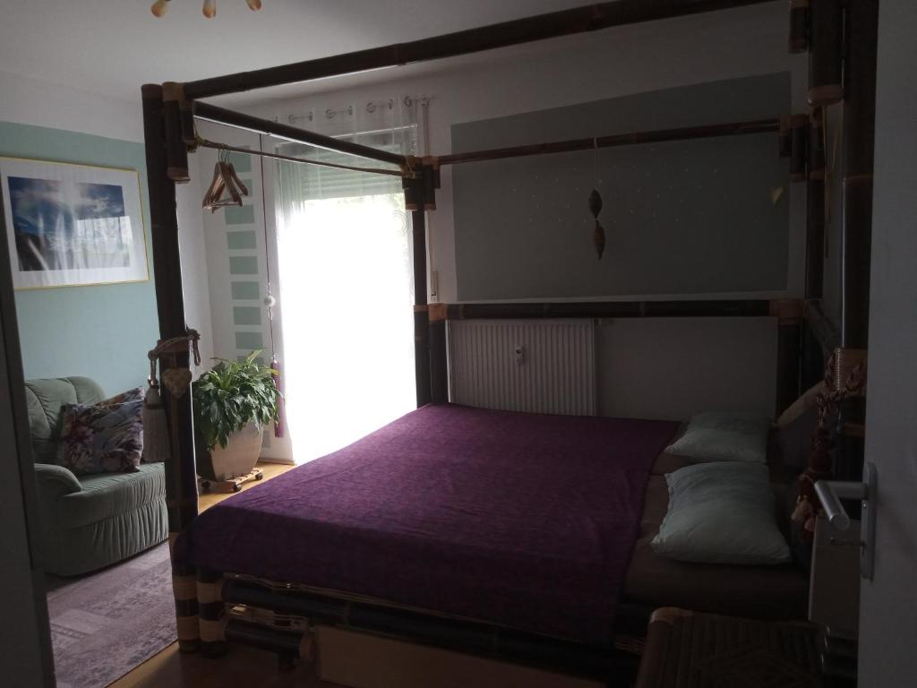 ein Schlafzimmer mit einem Himmelbett und einer lila Bettdecke in der Unterkunft Ferienwohnung in München