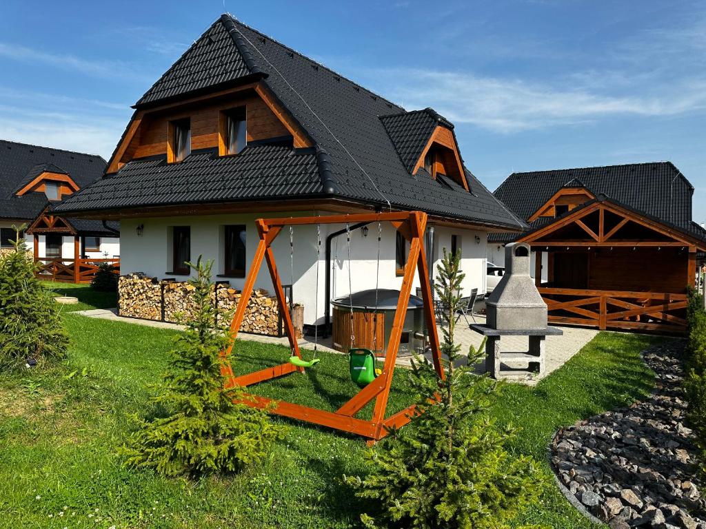 a house with a swing in front of it at Vila Svistovka in Stará Lesná