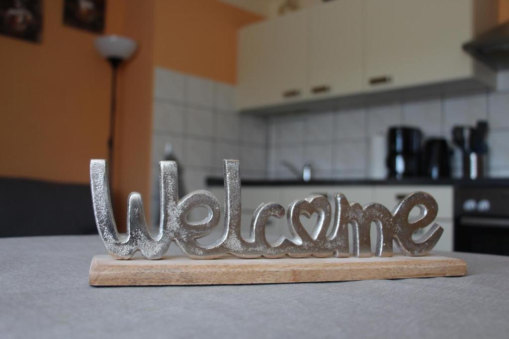 um sinal de metal que diz bem-vindo sentado numa mesa em Ferienunterkünfte Familie Berger em Dessau