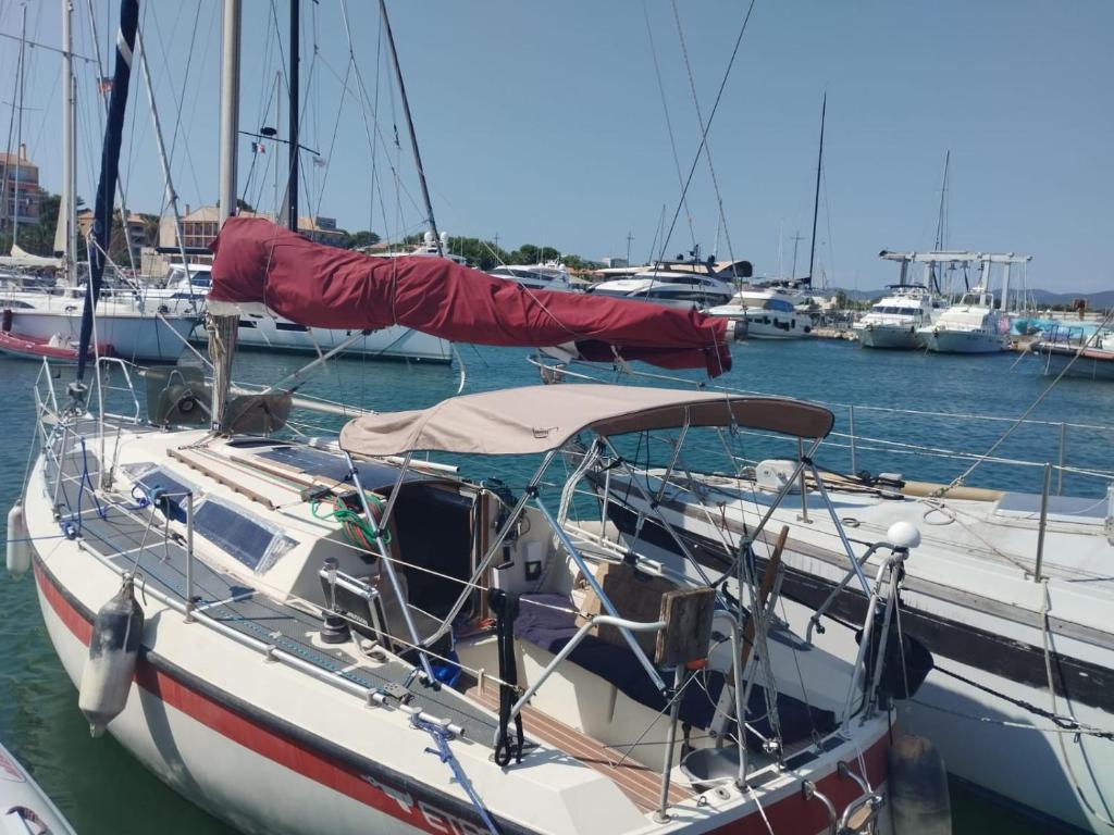 una barca è ormeggiata in un porto con altre imbarcazioni di Voilier à quai a La Londe-les-Maures