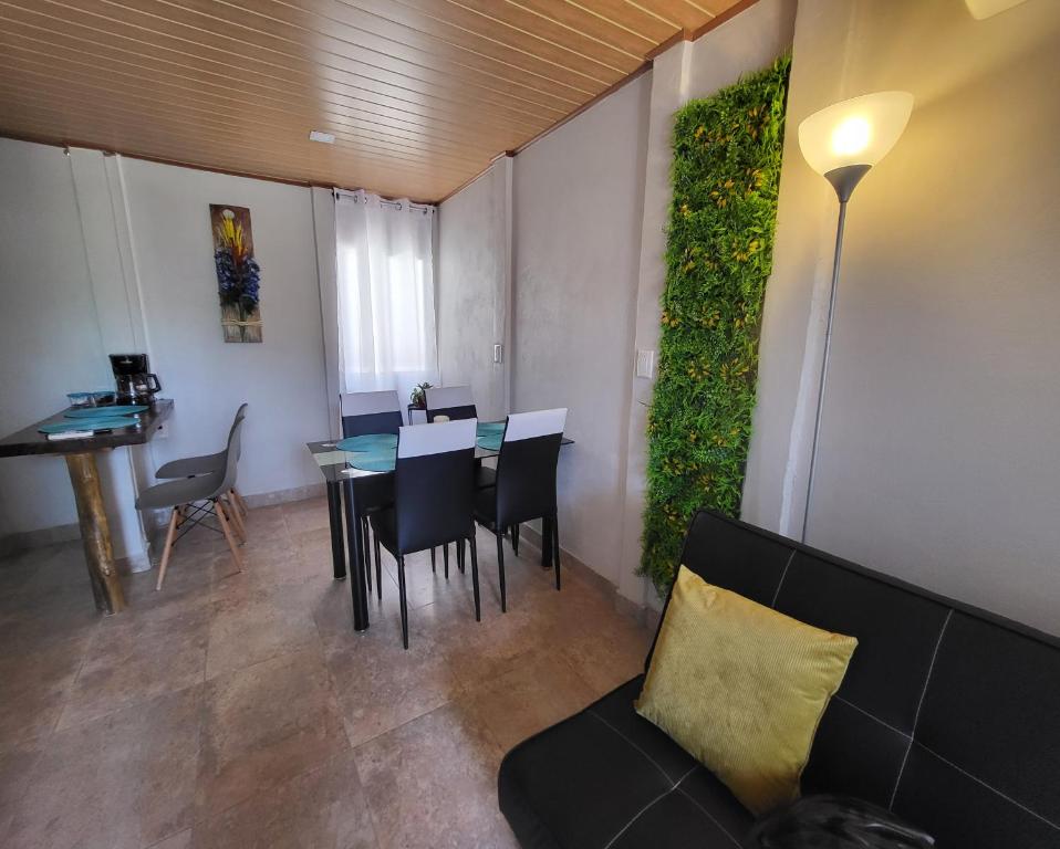 ein Wohnzimmer mit einem Sofa, einem Tisch und Stühlen in der Unterkunft MILA Apartments #1 in Barco Quebrado