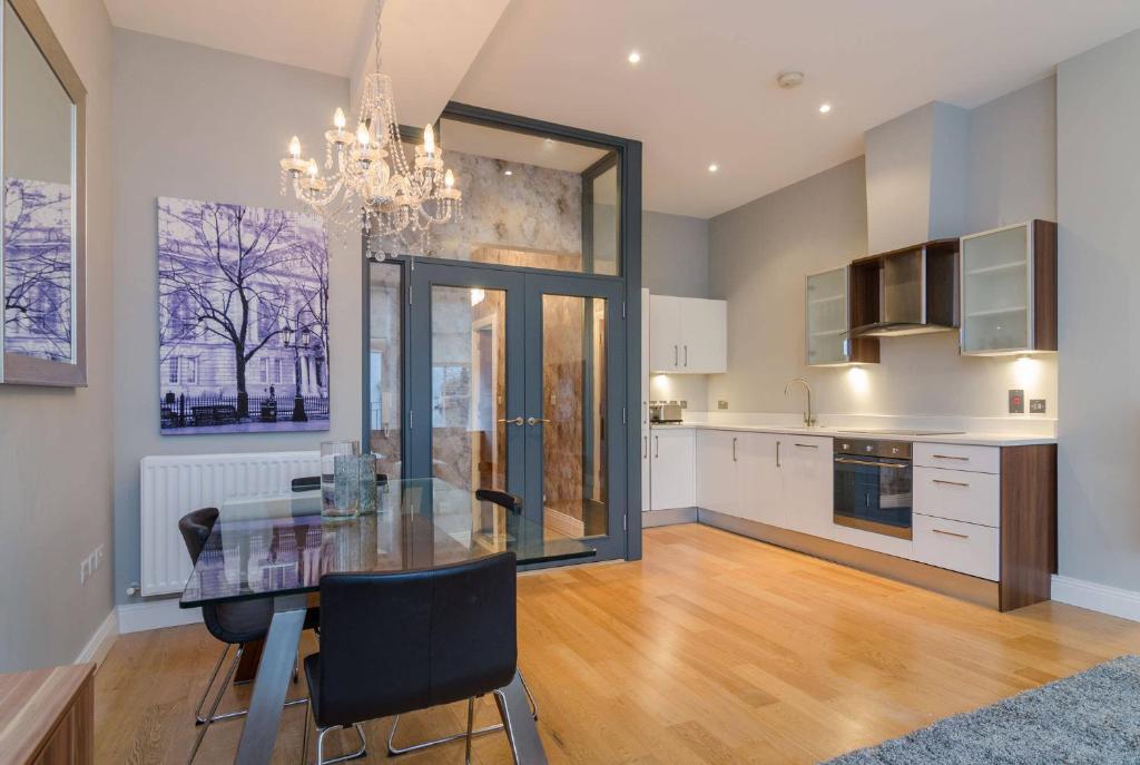 a dining room with a glass table in a kitchen at Fitzrovia Mansion Apartments in Belfast's Cathedral Quarter in Belfast