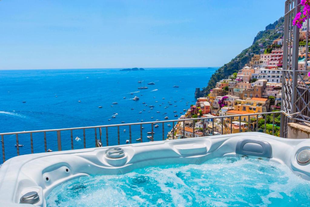 a hot tub on a balcony with a view of the ocean at AMORE RENTALS - Casa Volte Alte in Positano