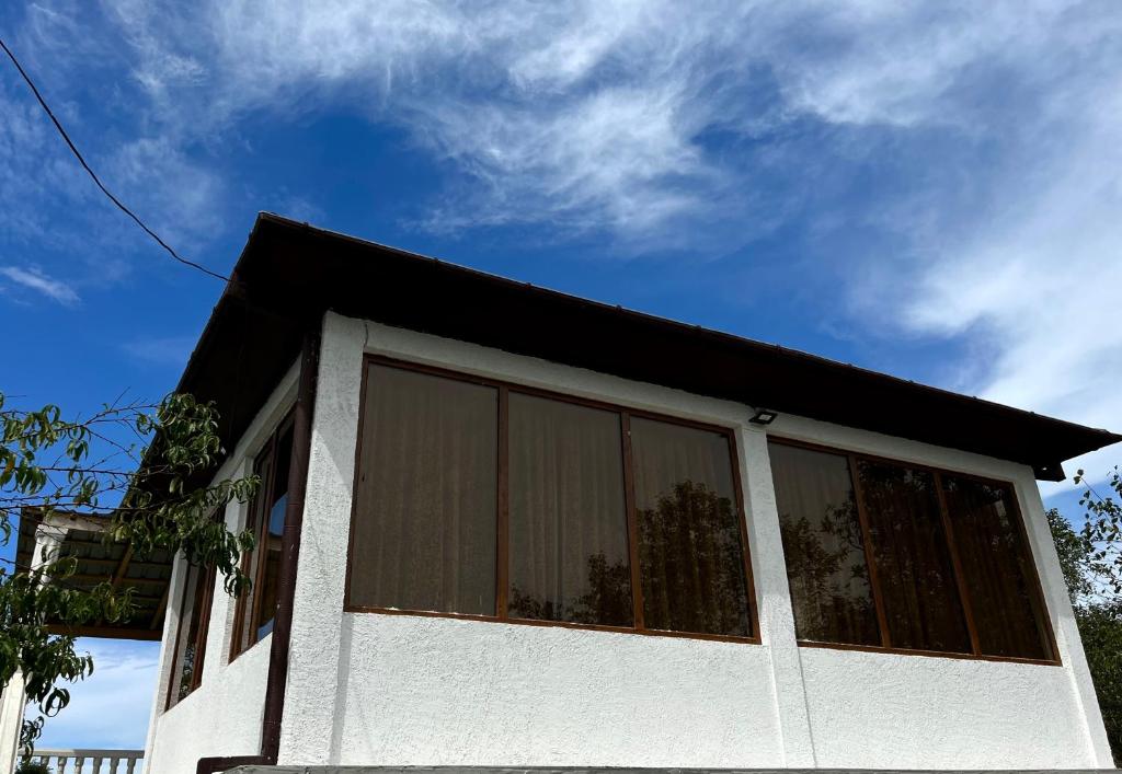 a white house with a black roof at Guest House MIRA in Martvili