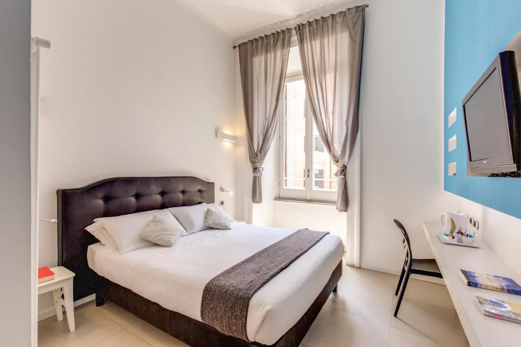 a bedroom with a bed and a desk and a television at Manin Suites LT in Rome