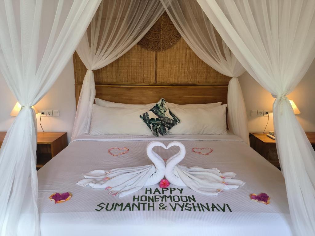a bed with a happy hmoon sign on it at Sawitri Anandhita Luxury Villas in Ubud