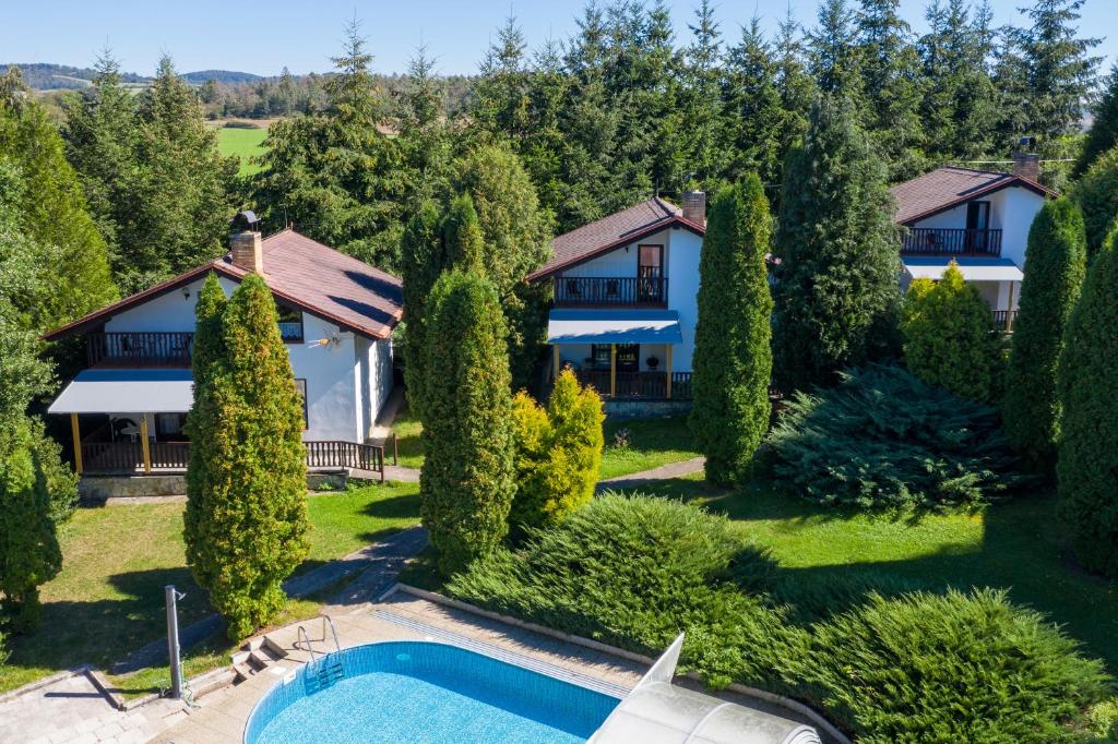 una vista aérea de una casa con piscina y árboles en Apartmány orlík en Klučenice