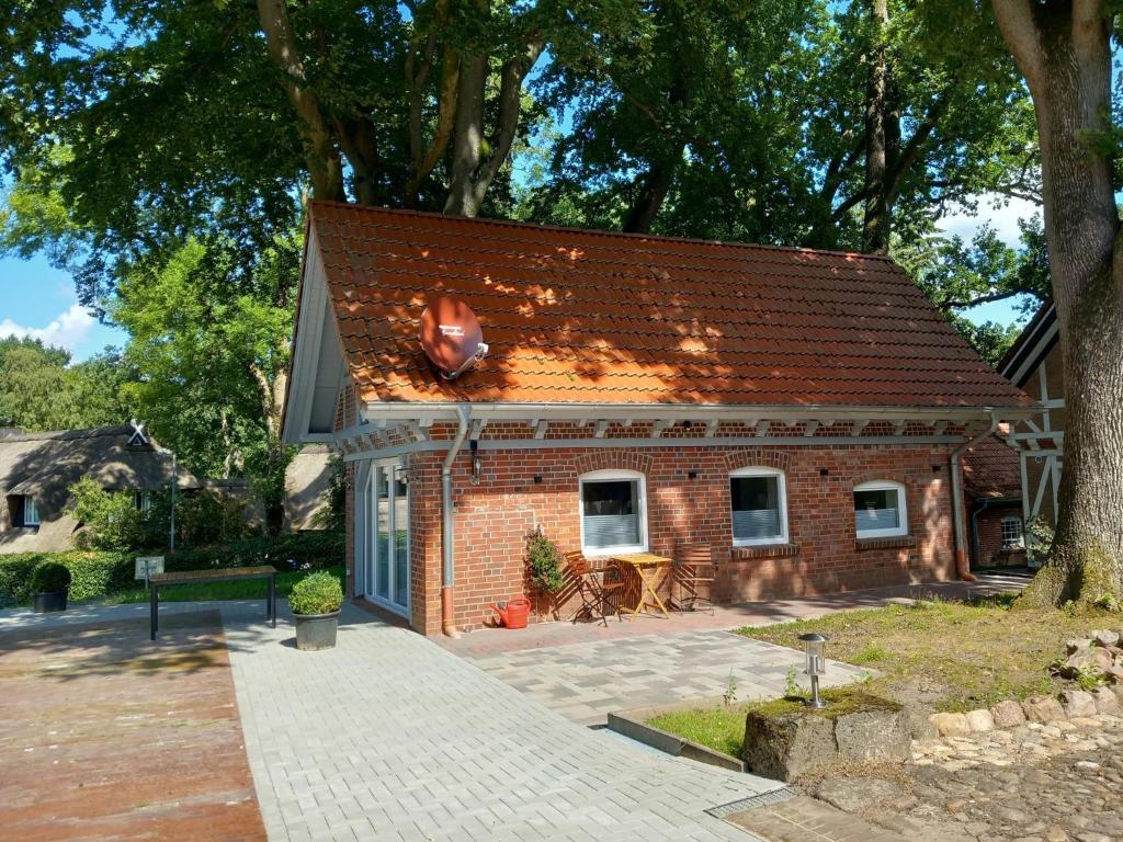 a small brick house with a table in front of it at Ferienhaus Heidenest, mit E-Bike Vermietung in Buchholz in der Nordheide