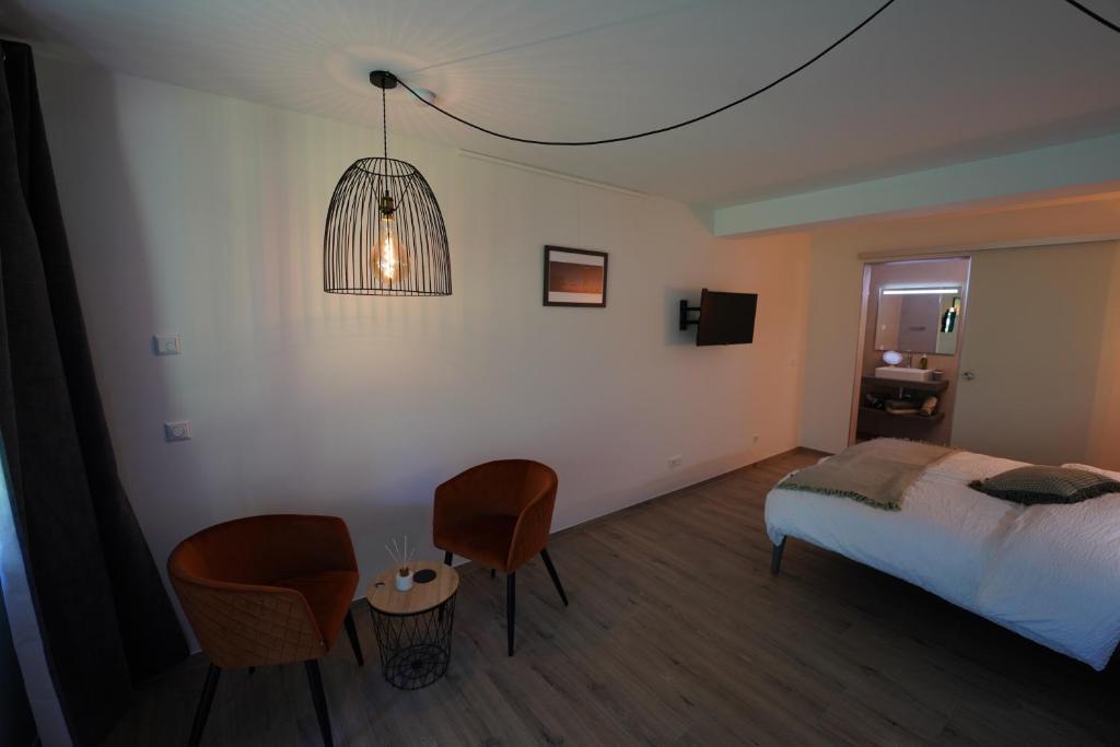 a bedroom with a bed and a table and chairs at B&B Alferweiher in Echternach