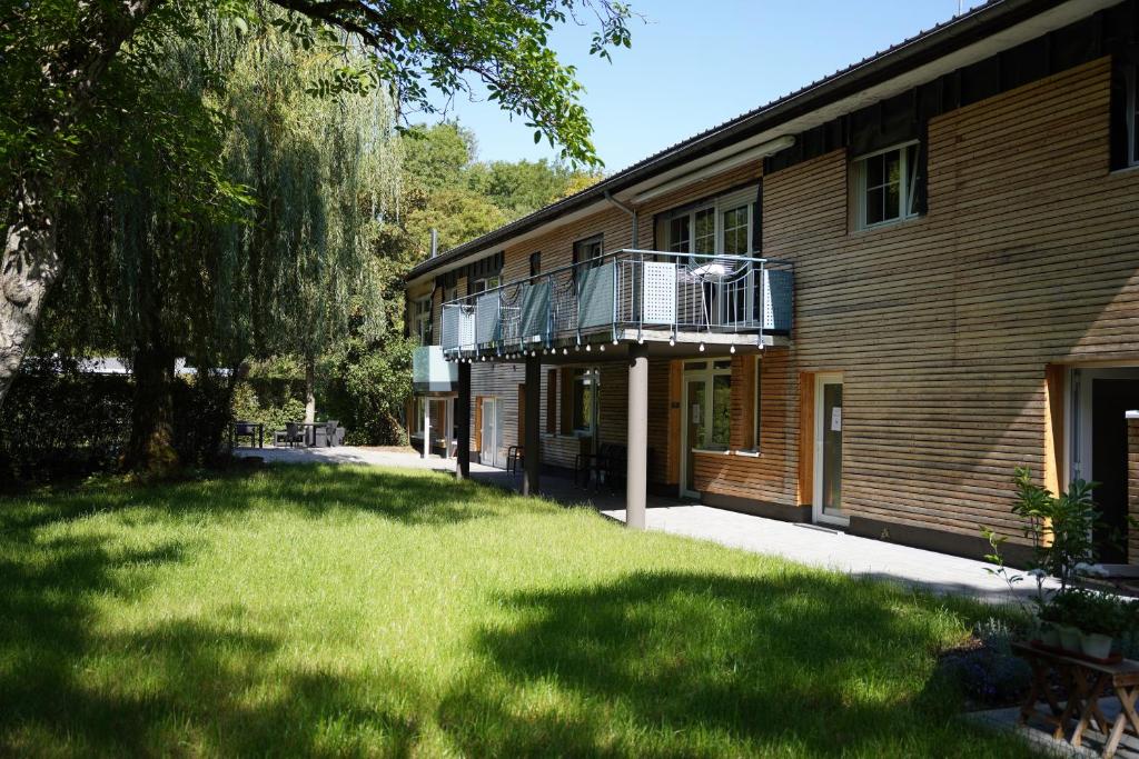 a building with a grass yard in front of it at B&B Alferweiher in Echternach