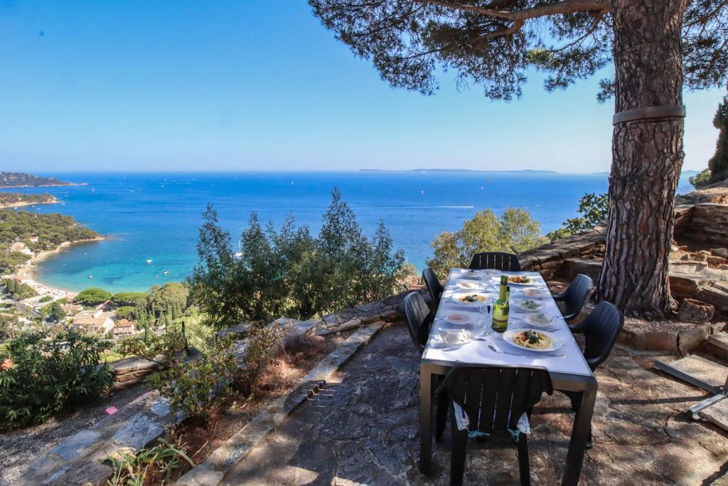 Una mesa y sillas con vista al mar. en La Lézardière, en Le Lavandou