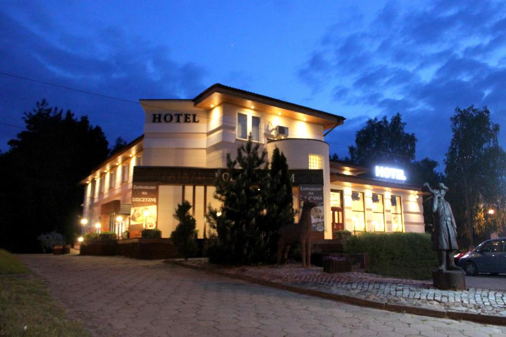 a hotel is lit up at night at Hotel Pod Jeleniem in Tuchola