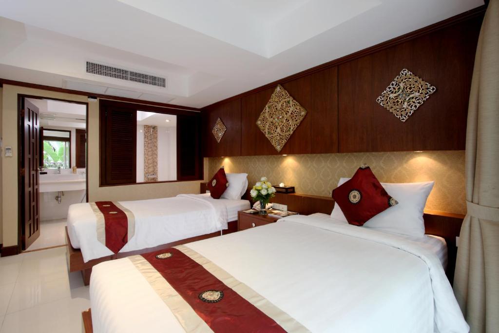 Postel nebo postele na pokoji v ubytování Rayaburi Hotel, Patong