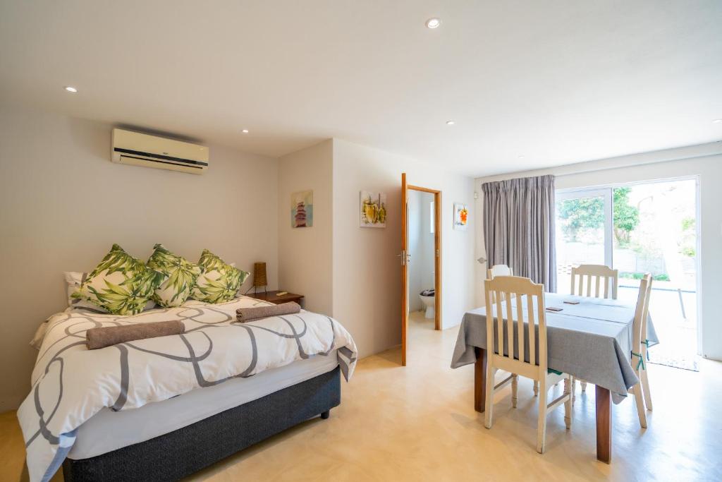 a bedroom with a bed and a table and a dining room at Danville Forest Villa in Durban