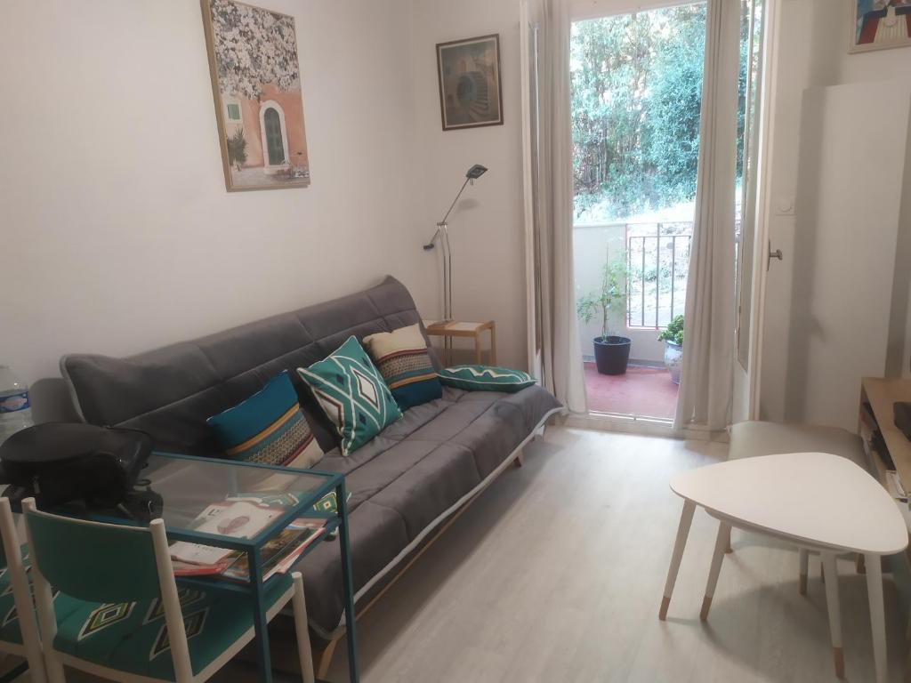 ein Wohnzimmer mit einem Sofa und einem Tisch in der Unterkunft Douceur d'Amélie in Amélie-les-Bains-Palalda