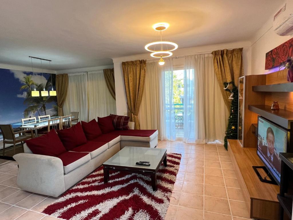 a living room with a red couch and a table at Luxury & stylish Naama bay flat at the centre of Sharm in Sharm El Sheikh