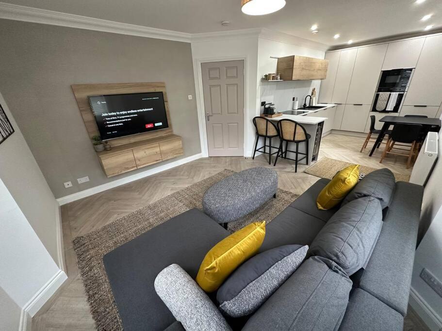 een woonkamer met een grijze bank en gele kussens bij Premium executive Apartment in Dunfermline in Dunfermline