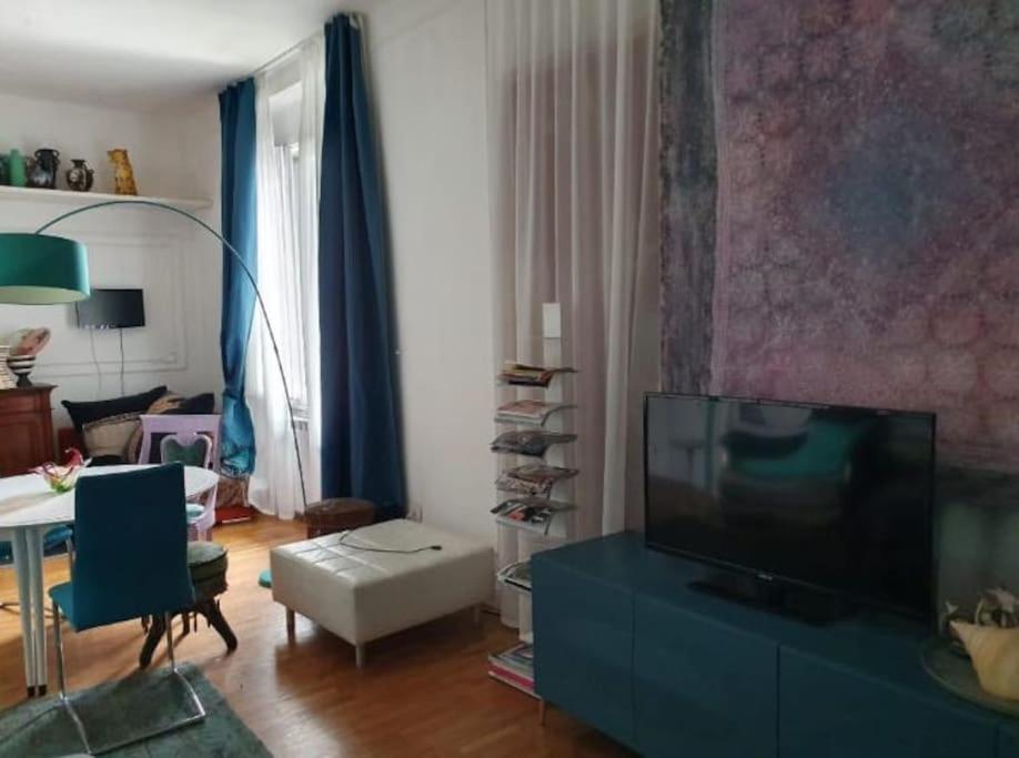 sala de estar con TV de pantalla plana y mesa en Villa Eclettica A POCHI METRI DAL MARE en Pesaro