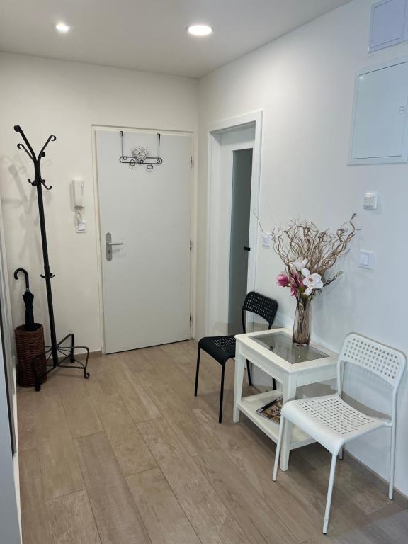 uma sala de estar branca com uma mesa e cadeiras em Apartment Maria em Mariánské Lázně