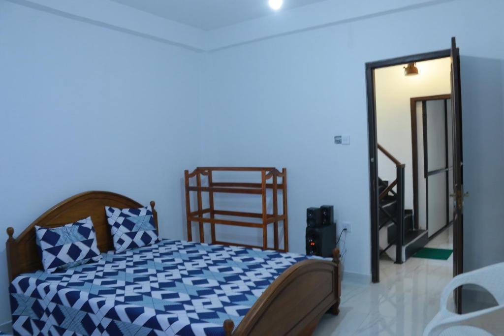 um quarto azul com uma cama e um espelho em Rochesta Holiday Inn em Badulla