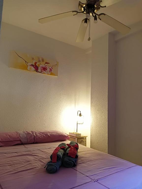 a bedroom with a bed with two pairs of shoes on it at Habitacion de matrimonio en Castilleja de la Cuesta in Castilleja de la Cuesta