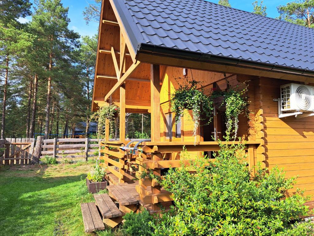 eine Holzhütte mit einer Veranda und einem Zaun in der Unterkunft Lesne Runo Borsk in Borsk