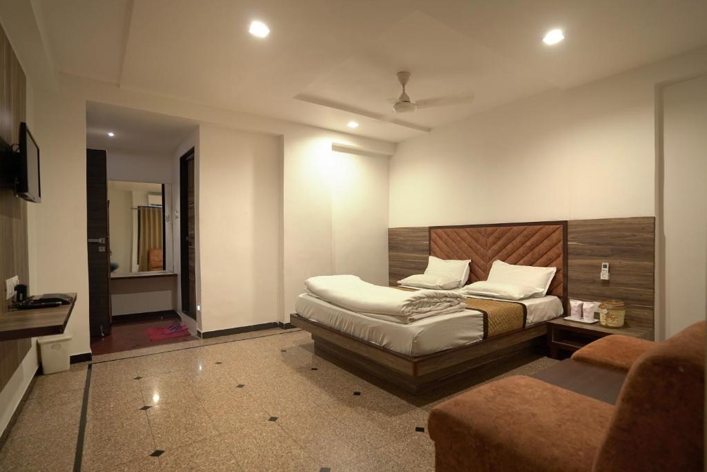 a bedroom with a bed with a wooden headboard at Hotel Shertown in Ahmedabad