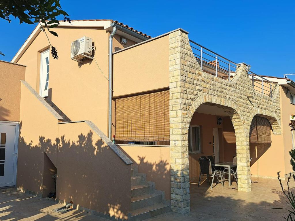 an external view of a house with an archway at Apartman Melita in Galižana