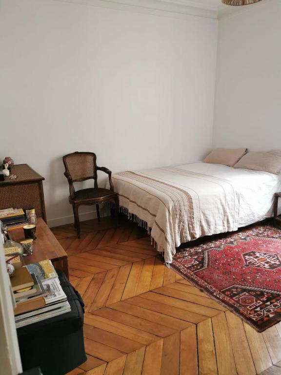 a bedroom with a bed and a table and a chair at Home sweet home in Paris