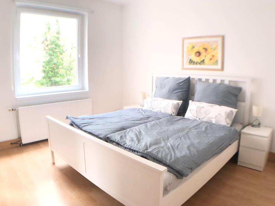 a white bed in a white bedroom with two windows at Cozy Apartment in Hannover Central in Hannover