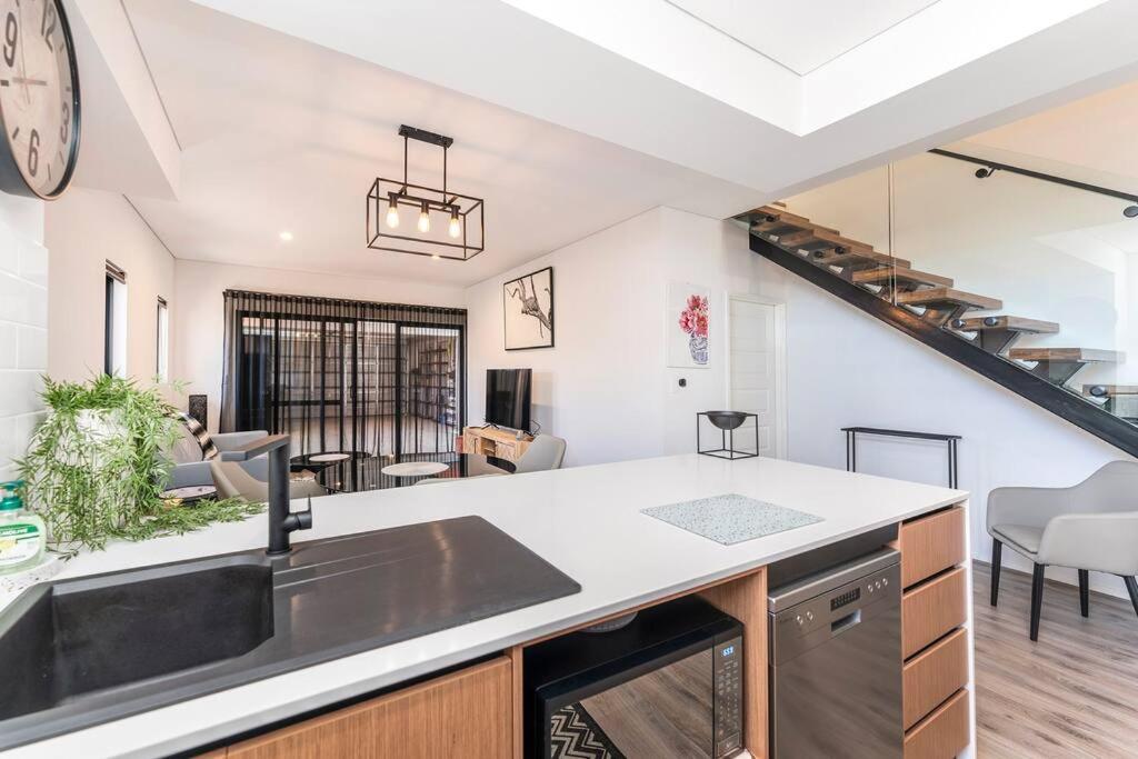 cocina abierta y sala de estar con escalera de caracol en Luxury Getaway Home, en Byford