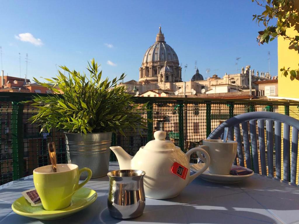 ein Tisch mit einer Teekanne und Tassen auf einem Balkon in der Unterkunft B&B Vatican Stories in Rom