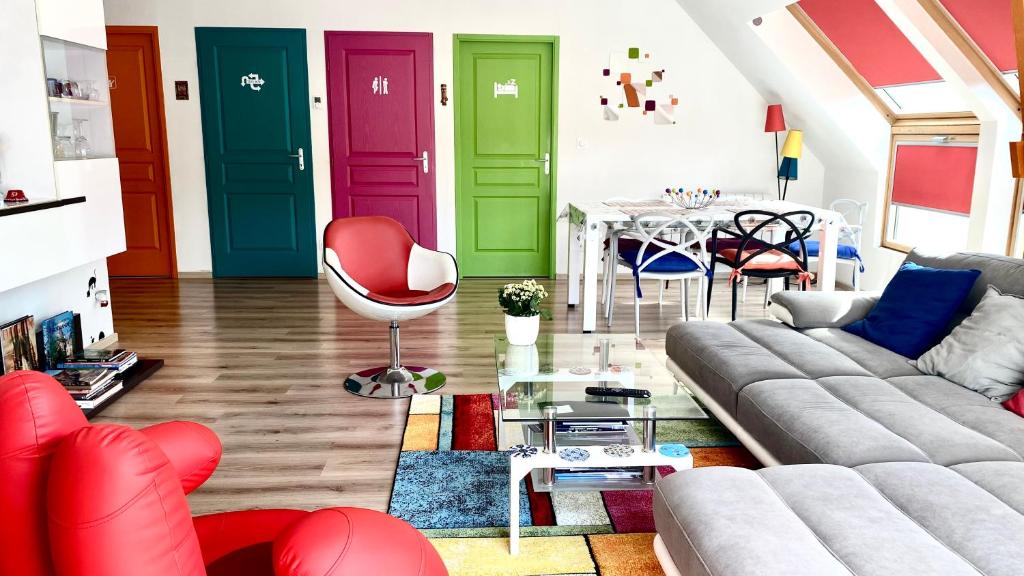 een woonkamer met kleurrijke deuren en een tafel bij La Seine en couleurs - juste rénové in Duclair