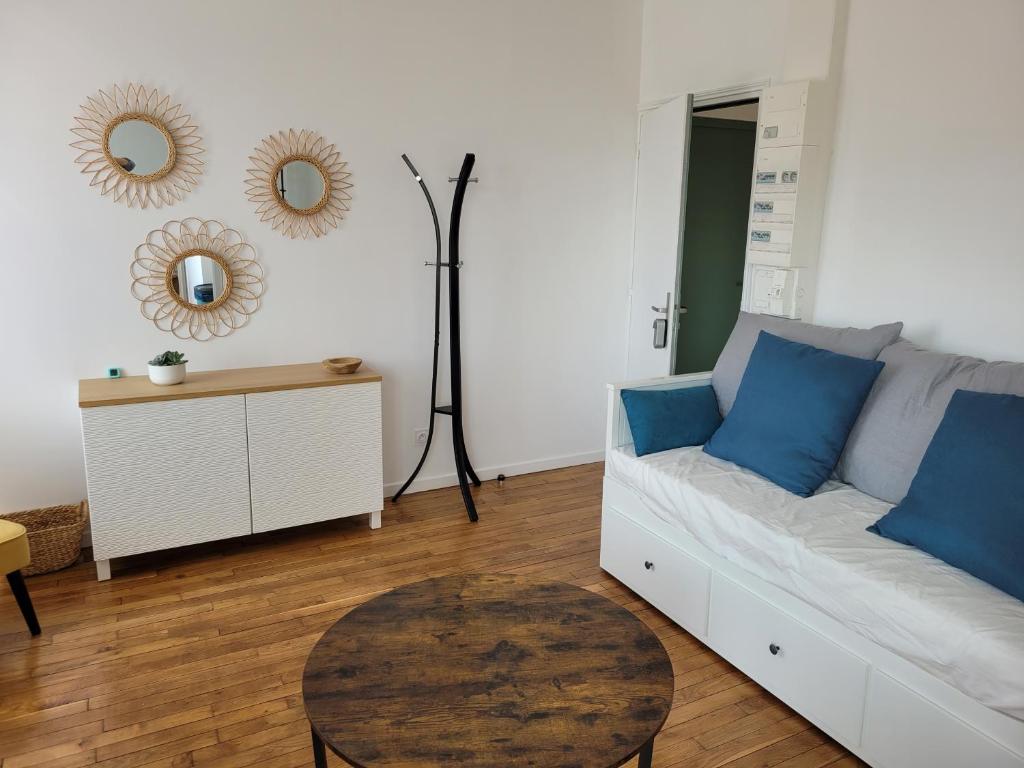 - un salon avec un canapé et une table dans l'établissement Appartement cosy, à Saint-Martin-Longueau