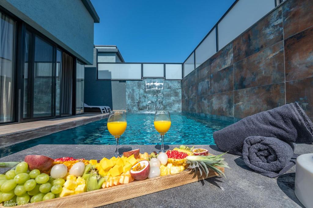 a tray of fruit and drinks next to a swimming pool at סוויטות בוטיק נעמי in Netu'a