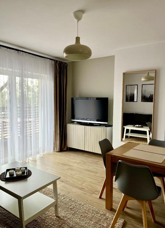 Televízia a/alebo spoločenská miestnosť v ubytovaní Apartamenty Lobeliowy Port