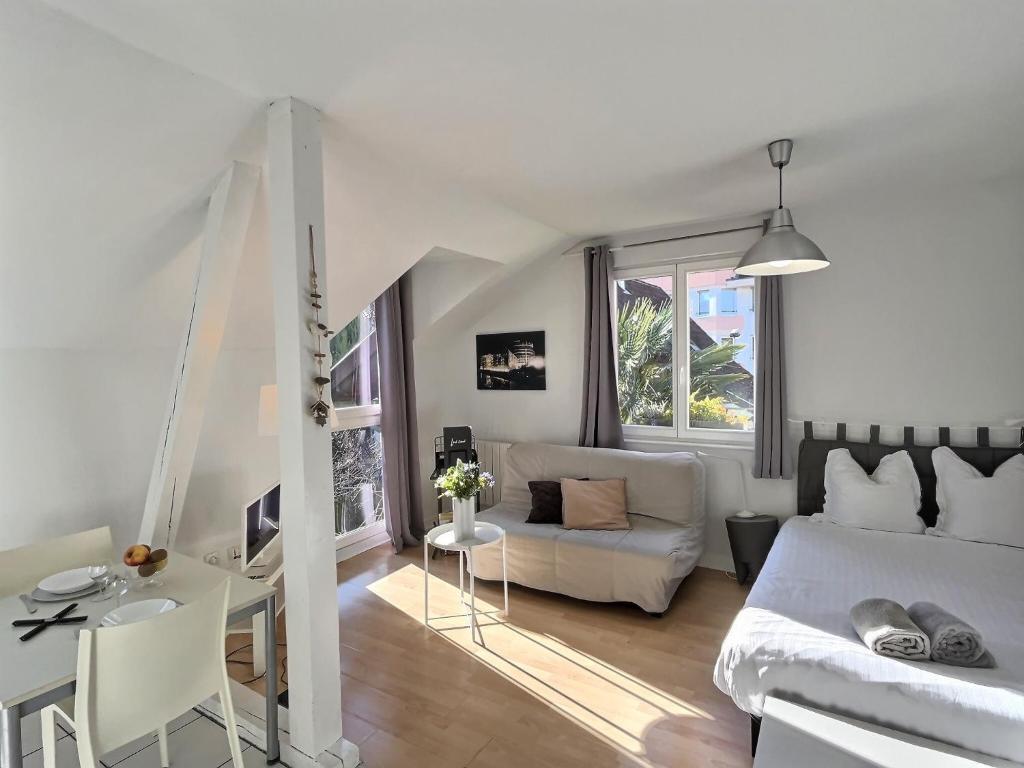 Sala de estar blanca con sofá y mesa en LES MARAICHERS en Estrasburgo
