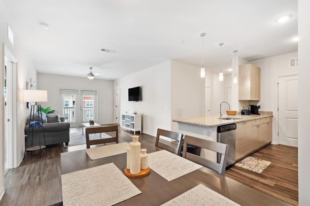 uma cozinha branca e sala de estar com mesa e cadeiras em Lavish 2BR Apartment in Tampa em Tampa