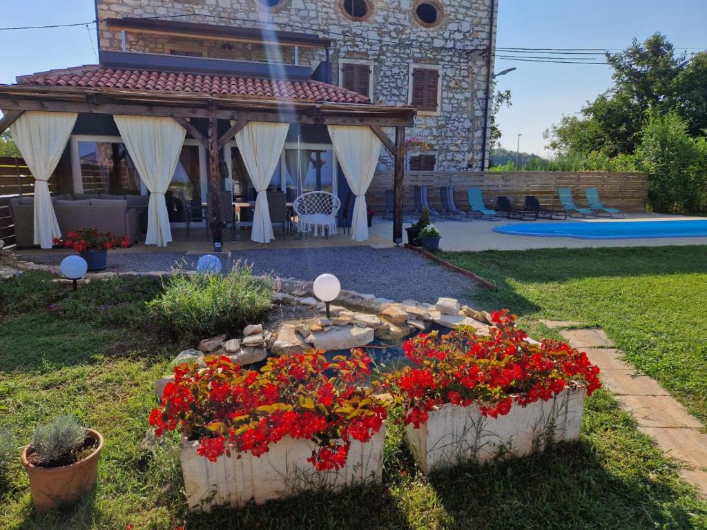 ogród z kwiatami przed domem w obiekcie Villa Makale w mieście Umag