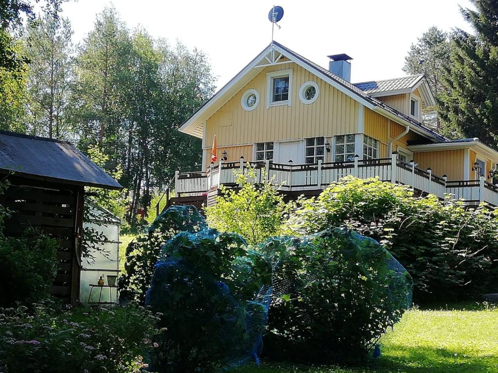 a yellow house with a garden in front of it at Villa Koskikorento in Kannus