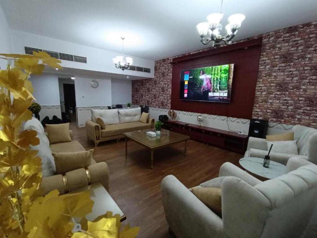 a living room with couches and a brick wall at شقة كبيرة وفخمة large and luxury two bedroom in Ajman 