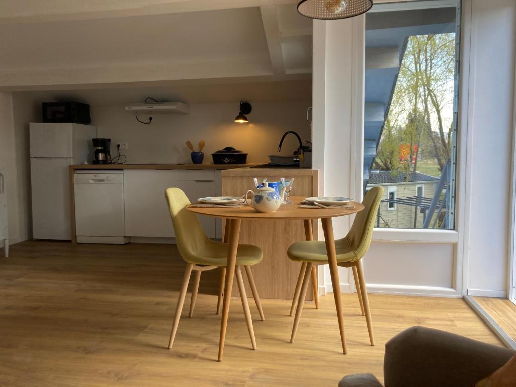 une table et des chaises dans une cuisine avec une fenêtre dans l&#39;établissement Camping Mas Piques, à Bourg-Madame