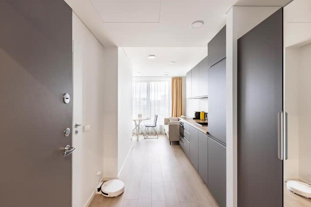 a kitchen with gray cabinets and a white floor at Ozo eco apartments in Vilnius