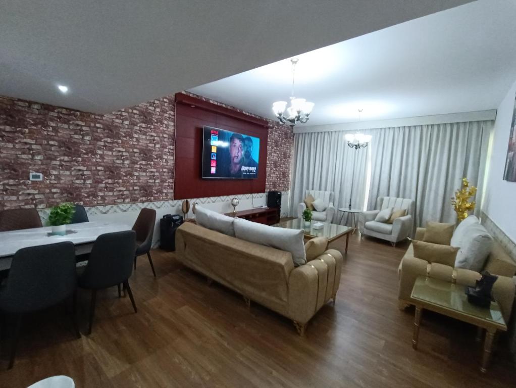 شقة كبيرة وفخمة large and luxury two bedroom في عجمان: غرفة معيشة مع كنب وجدار من الطوب