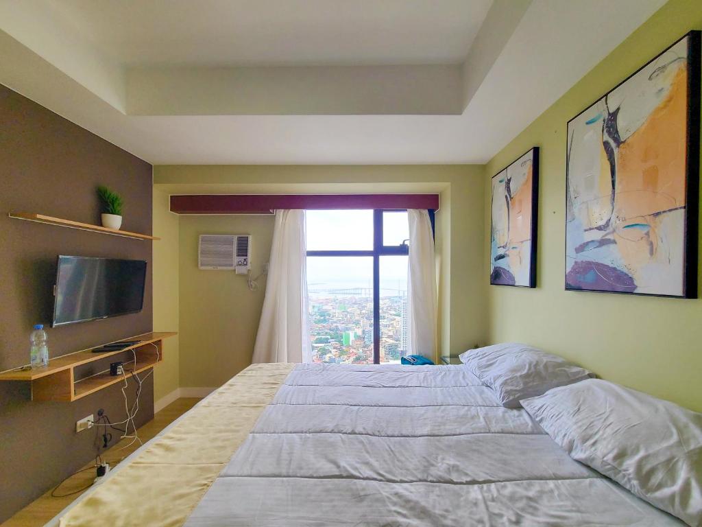 um quarto com uma cama grande e uma janela em Suite 1 Bedroom with Seaview-Horizons 101 em Cebu