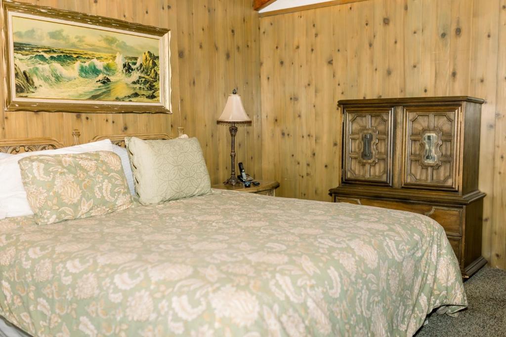 1 dormitorio con 1 cama y una foto en la pared en Redican's Retreat - Great lake view home located near the falls, en Bass Lake