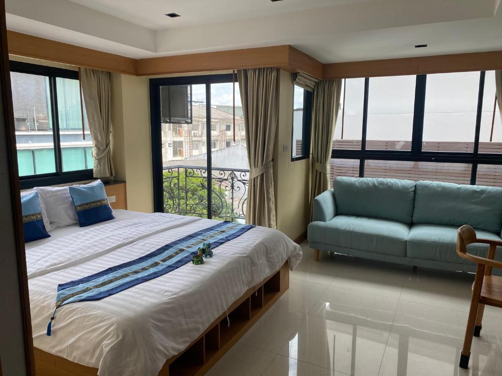1 dormitorio con 1 cama grande y 1 sofá en L18 residence แอลสิบแปด เรสซิเดนซ์ en Ban Zong Katiam