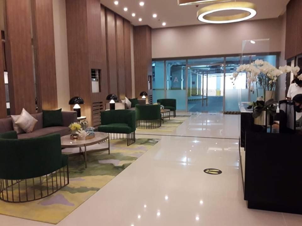 a lobby with couches and tables in a building at Residential Resort Condo by the Bay in Manila