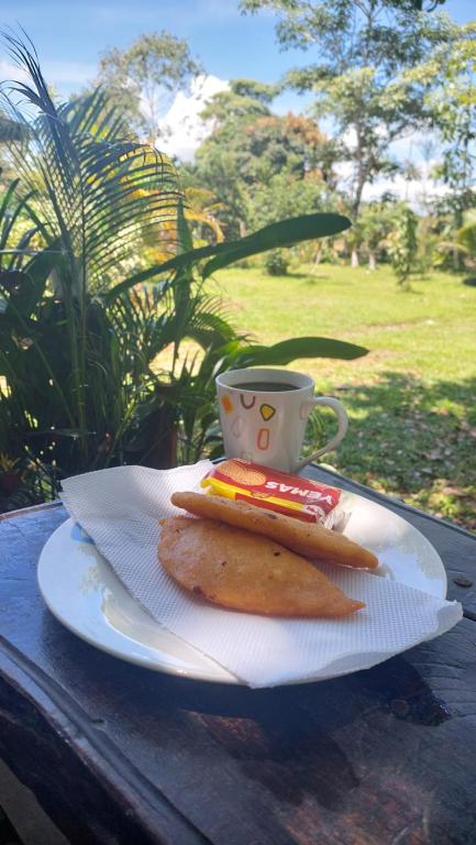 een bord met een broodje en een kopje op een tafel bij El Encanto Caño Negro in Caño Negro