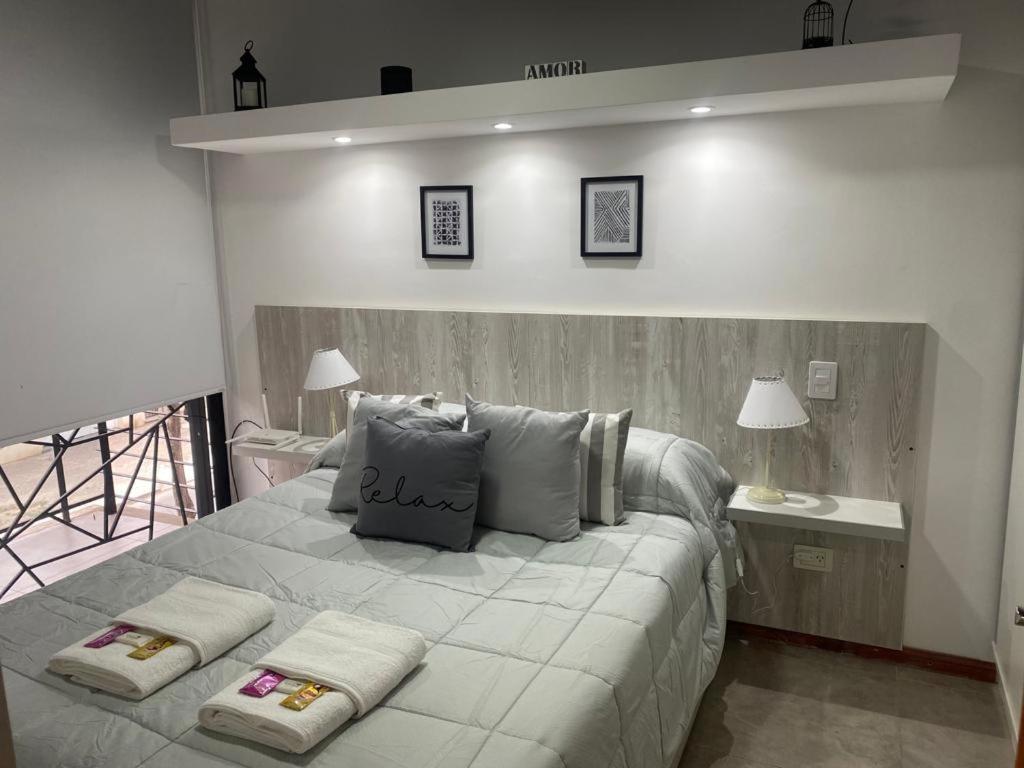 1 dormitorio con 1 cama grande y 2 almohadas en DEPARTAMENTO VERA MUJICA 4 COHERA PROPIA INCLUIDA en Rosario